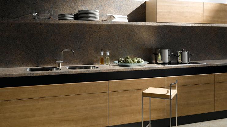 Küchenzeile aus Massivholz mit dunkler Arbeitsplatte Küchenzeile aus Massivholz mit schwarzer Arbeitsplatte, Spülbecken und Wandregal